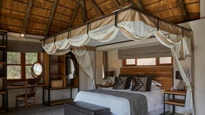 A bedroom with a canopy bed, a desk, a chair, and a mirror. - Toro River Lodge (Kareeberg)