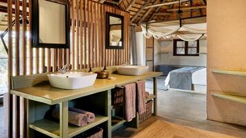 Een badkamer met twee wasbakken, een spiegel en een houten wastafelmeubel.