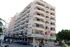 A multi-story hotel with balconies, a sign for 'Joseph's Boutique,' and a 'Hotel Joseph' sign. - Stjosephhotel (Luxor)