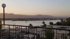 Ein Blick auf einen Fluss mit Booten, eine ferne Stadtlandschaft und einen klaren Himmel.