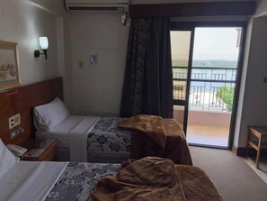 A hotel room with two beds, a balcony with a railing, and a view of the outdoors. - Stjosephhotel (Luxor)