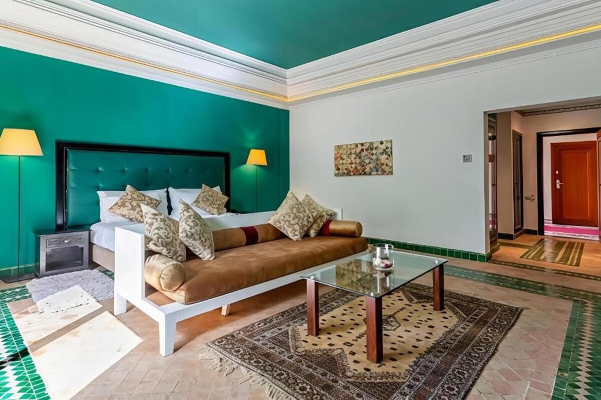 Ein Hotelzimmer mit Bett, Sofa und einem Glastisch.