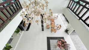 Un lobby espacioso con una gran lámpara de araña, un comedor y un arreglo floral decorativo.