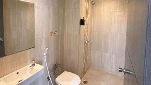 Un baño moderno con inodoro, lavabo y ducha.