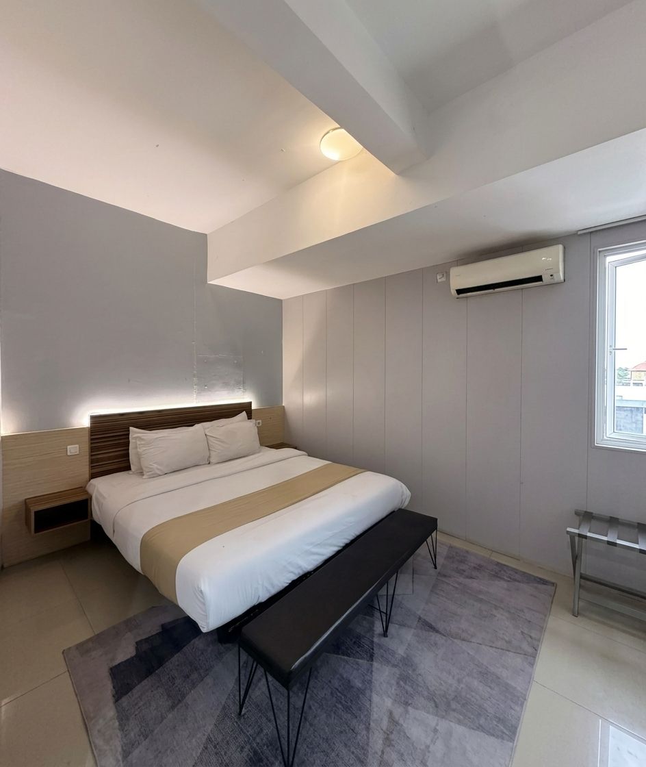 Une chambre à coucher moderne, comprenant un lit, des tables de chevet, un banc et un appareil de climatisation.