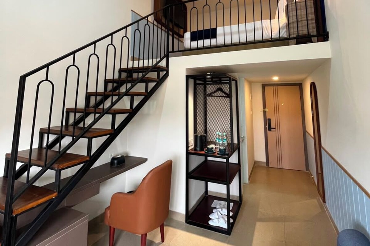 A modern interior with a staircase, a seating area, and a small table with items on it.