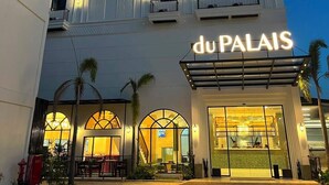 A hotel with a prominent 'du PALAIS' sign, multiple balconies, and a well-lit entrance. - Du Palais Hotel (Jambi)