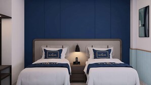 A hotel room with two beds, a nightstand, a lamp, and a painting on the wall. - Du Palais Hotel (Jambi)