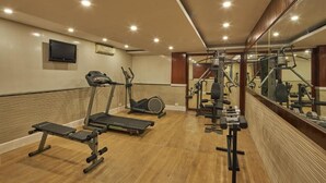 Un gimnasio con cintas de correr, elípticas y equipo de pesas.