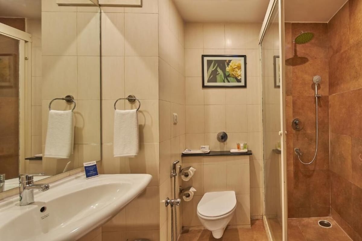 Een badkamer met een wastafel, toilet en douche.