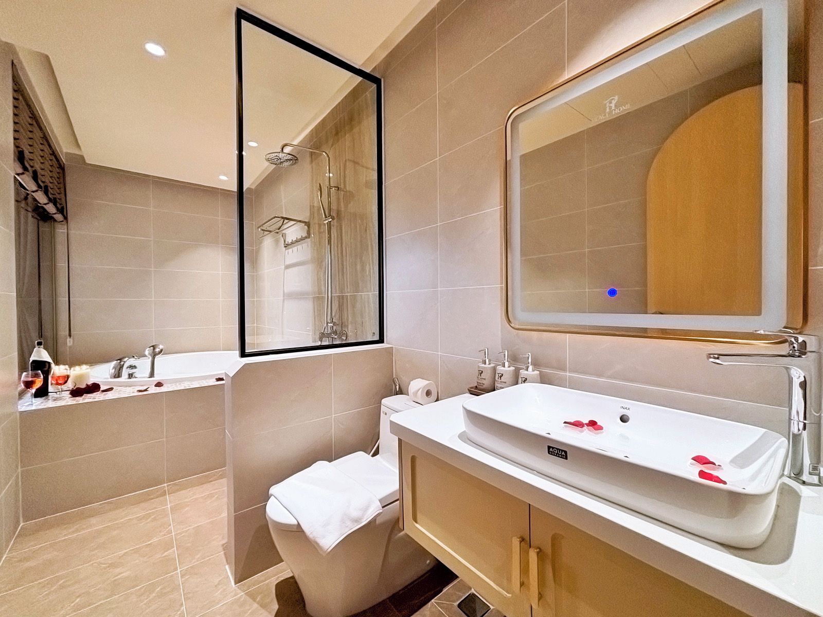 Ein modernes Badezimmer mit Badewanne, Waschbecken, Toilette und einem großen Spiegel.
