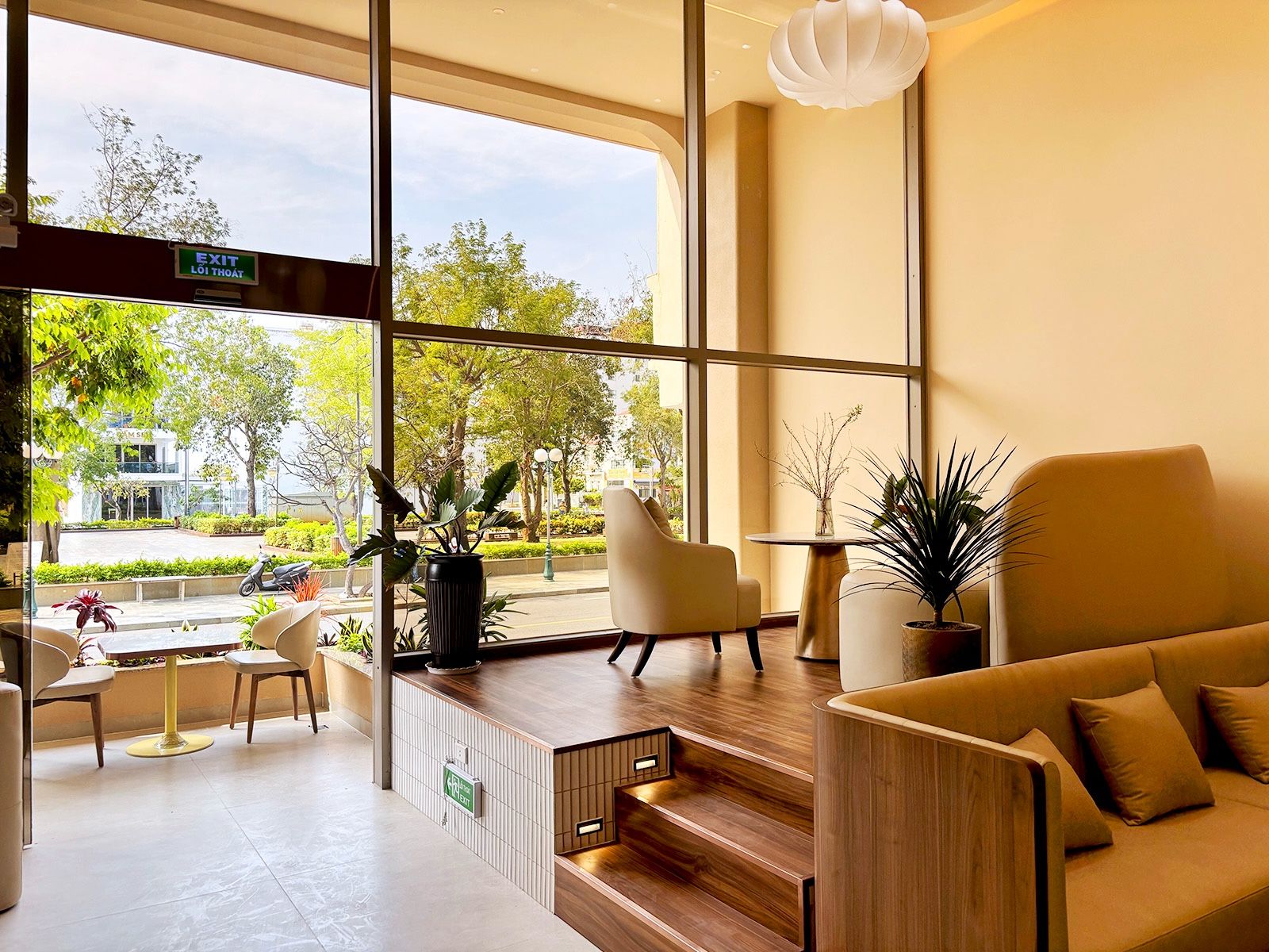 Een modern interieur met een zithoek, een trap en grote ramen met uitzicht op het omliggende landschap.