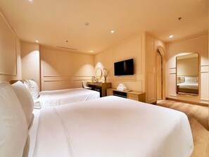 A hotel room with two beds, a desk, a television, a mirror, and a bathroom mirror. - Peace Home Boutique Hotel Phan Thit (Phu Thuy)