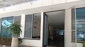 A building entrance with a potted plant, a Christmas decoration, and a staircase leading to a covered area. - Hotel Saman Del Rio (Yopal)