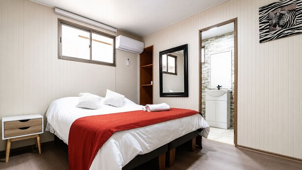 Ein Schlafzimmer mit Bett, Nachttisch und Kleiderschrank.