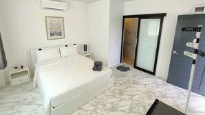 A hotel room with a bed, a nightstand, an air conditioning unit, a wall-mounted sign, a sliding door, and a directional signpost. - Z-beach Resort (Pranburi)
