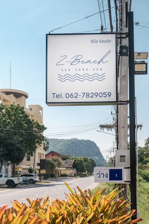 A signboard with the name '2-Beach' and a contact number.