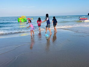 Children playing on a beach with inflatable toys and a jet ski in the background. - Z-beach Resort (Pranburi)