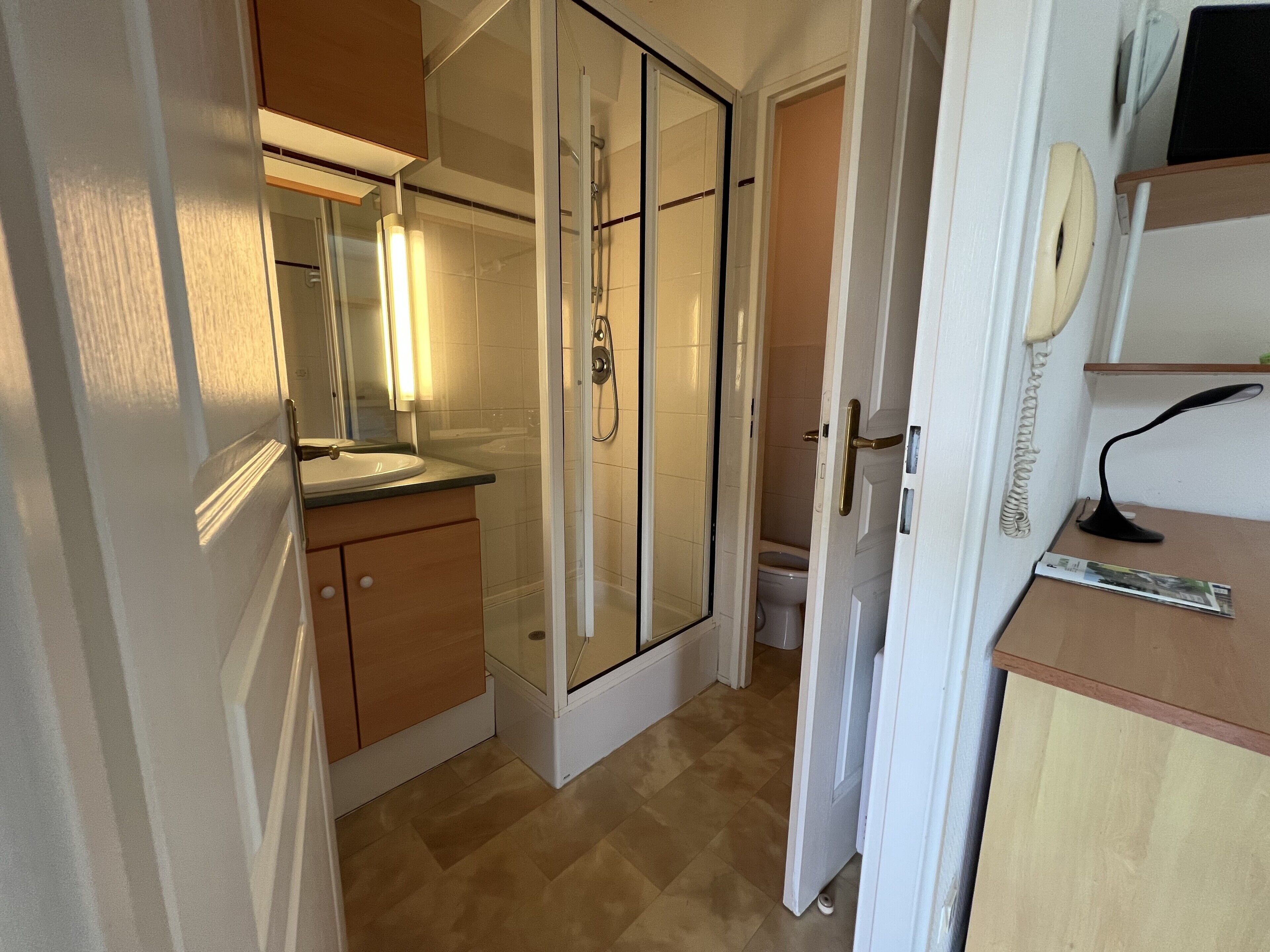 A bathroom with a shower, toilet, and sink.