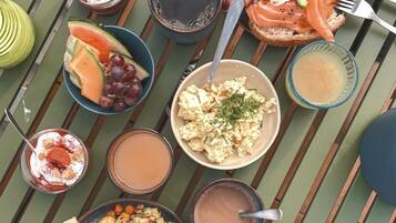 Une variété d’aliments et de boissons pour le petit-déjeuner, disposés sur une table en bois.