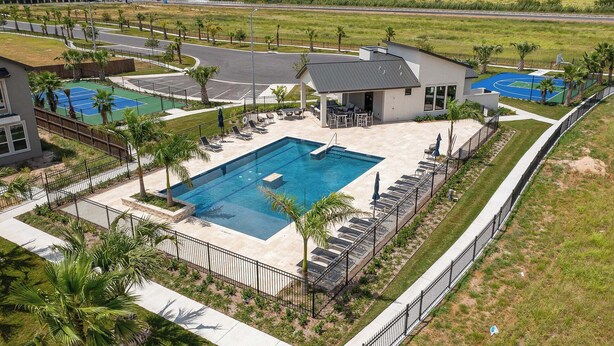 A residential area with a swimming pool, tennis courts, and a view of a highway. - The House Mcallen 3bdroom Pool (McAllen)