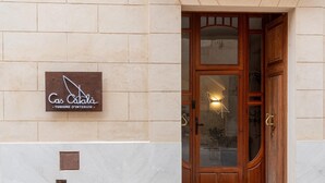 A building entrance with a wooden door, a sign reading 'Cas Català - Tourism Interior,' and a light fixture above the door. - CAS CATALÀ - DOBLE ECONOMY - Beautiful room in a boutique hotel with shared pool and free (Sineu)