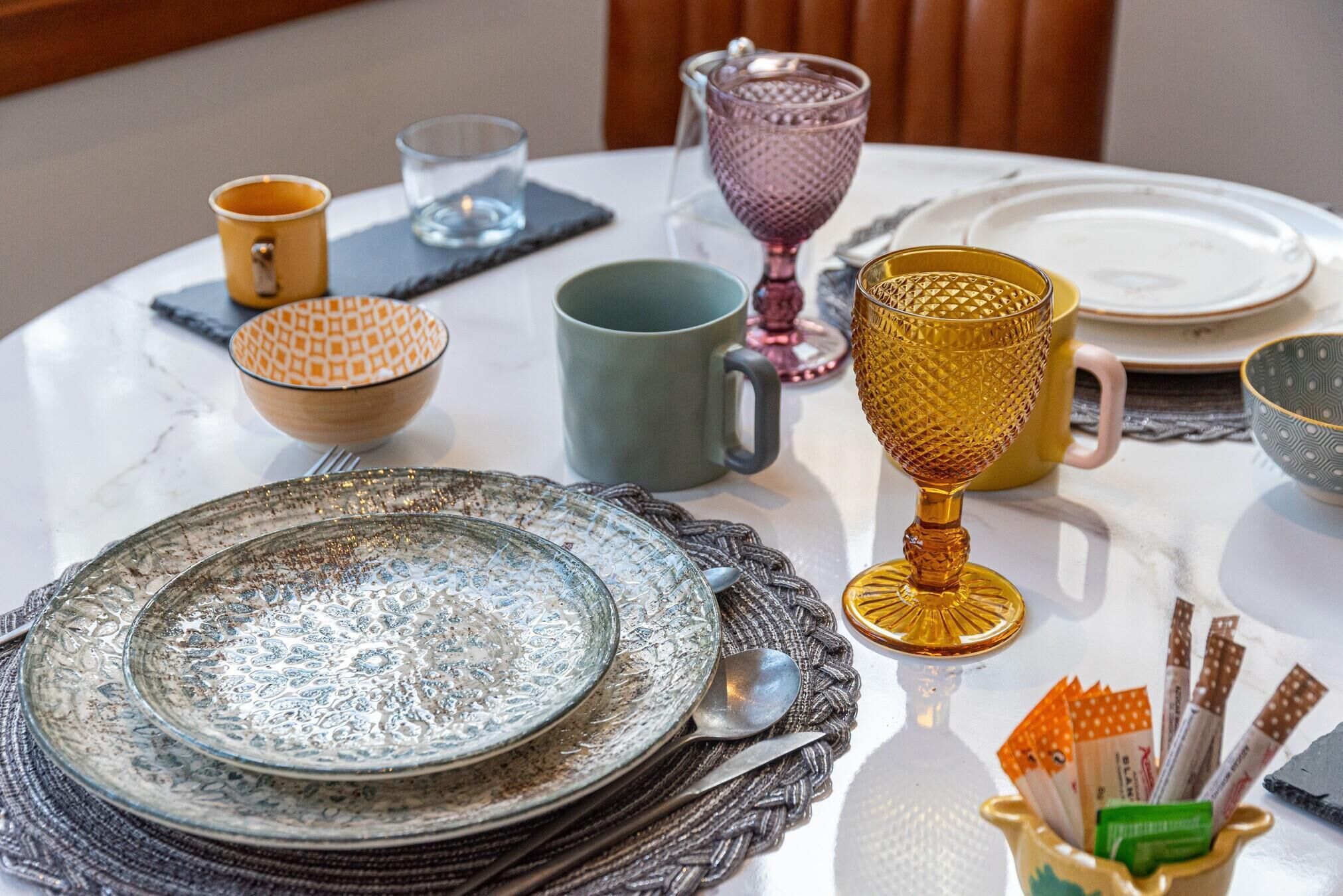 Een eettafel met verschillende gerechten, glazen en bestek.