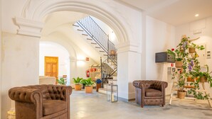 A spacious living area with a staircase, two leather armchairs, and potted plants. - CAS CATALÀ - DOBLE ECONOMY - Beautiful room in a boutique hotel with shared pool and free (Sineu)