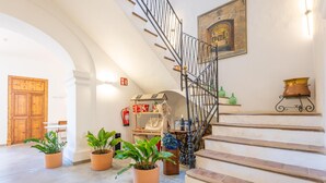 A staircase with a wrought iron railing, a wooden door, and potted plants. - CAS CATALÀ - DOBLE ECONOMY - Beautiful room in a boutique hotel with shared pool and free (Sineu)