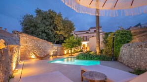 A pool area with stone walls, a wooden bench, and a table. - CAS CATALÀ - DOBLE ECONOMY - Beautiful room in a boutique hotel with shared pool and free (Sineu)