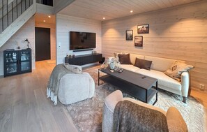 A modern living room with a sofa, coffee table, and entertainment unit.