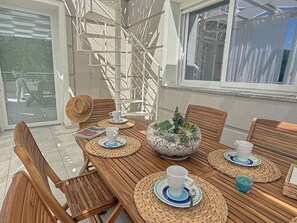 Ein Holztisch mit gewebten Tischsets, weißen Tassen und einer dekorativen Schale mit Sukkulenten.