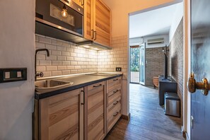 A kitchen with wooden cabinets, a stainless steel sink, and a brick backsplash.