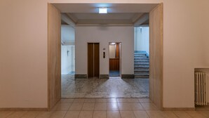 A hallway with a marble floor, wooden doors, and a staircase. - Camilluccia Quiet Corner (Roma)