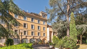 A multi-story building with a central courtyard, surrounded by greenery and trees. - Camilluccia Quiet Corner (Roma)