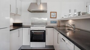 A modern kitchen with a stainless steel range hood, a built-in oven, and a dishwasher. - Lovely home in Hvide Sande with sauna (Hvide Sande)