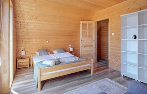 A wooden cabin bedroom with a bed, bedside tables, and a wardrobe. - Awesome home in Dobieslawiec with sauna (Dobieslawiec)