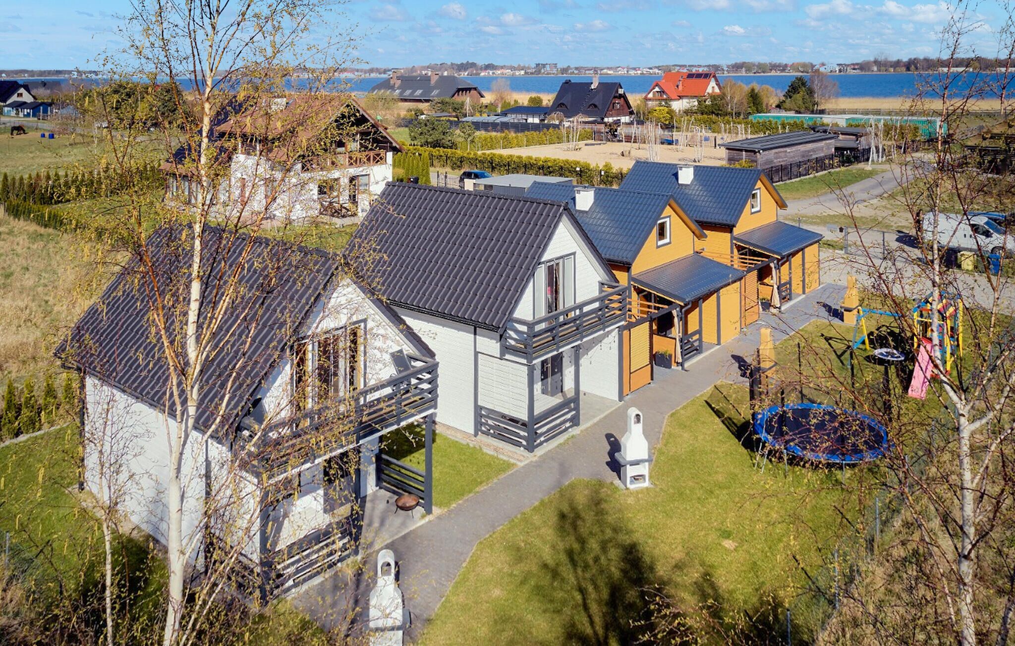 Een woongebied met huizen, een speeltuin en een waterpartij op de achtergrond.