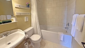 Une salle de bain comprenant des toilettes, un lavabo, une baignoire et une douche.