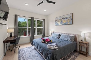 A bedroom with a bed, desk, chair, and a window with curtains. - New Construction | Lake View Retreat (Gun Barrel City)