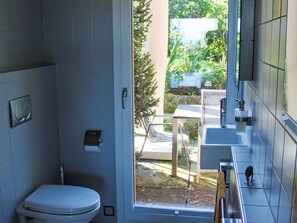 Ein Badezimmer mit Toilette, Waschbecken und Duschbereich.