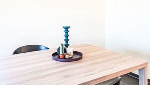 A wooden table with a tray holding a teal candle holder, a small cactus, and a candle.