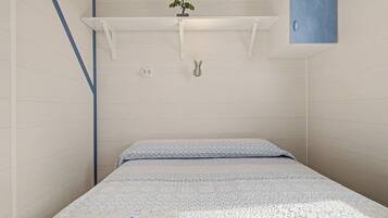 A small, single-bed room with a patterned bedspread, a wall-mounted shelf with a plant, and a blue cabinet.