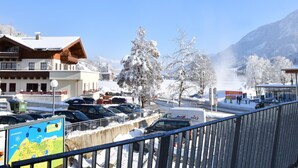 A snow-covered town with a ski resort, including a hotel with a wooden facade and a mountain backdrop. - Luxury apartment with wellness next to gondola (Brixen im Thale)