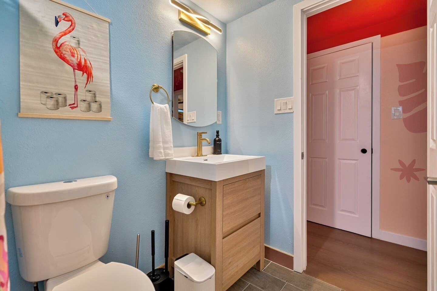A bathroom with a toilet, sink, and mirror.