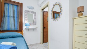 Un dormitorio con cama, mesita de noche, espejo y armario.