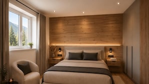 Un dormitorio moderno con una cama grande, mesitas de noche, una silla y una ventana con vistas a árboles.
