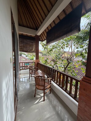 A balcony with a wooden railing, a table, and chairs. - Room-a Quiet Room With Balcony in Nyuh K (Ubud)