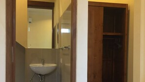 Un bagno con lavandino, specchio e mobiletto in legno.