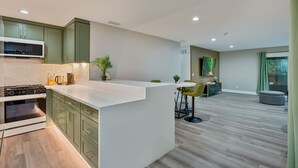 Una cocina moderna con una isla central, electrodomésticos integrados y un comedor con vistas.